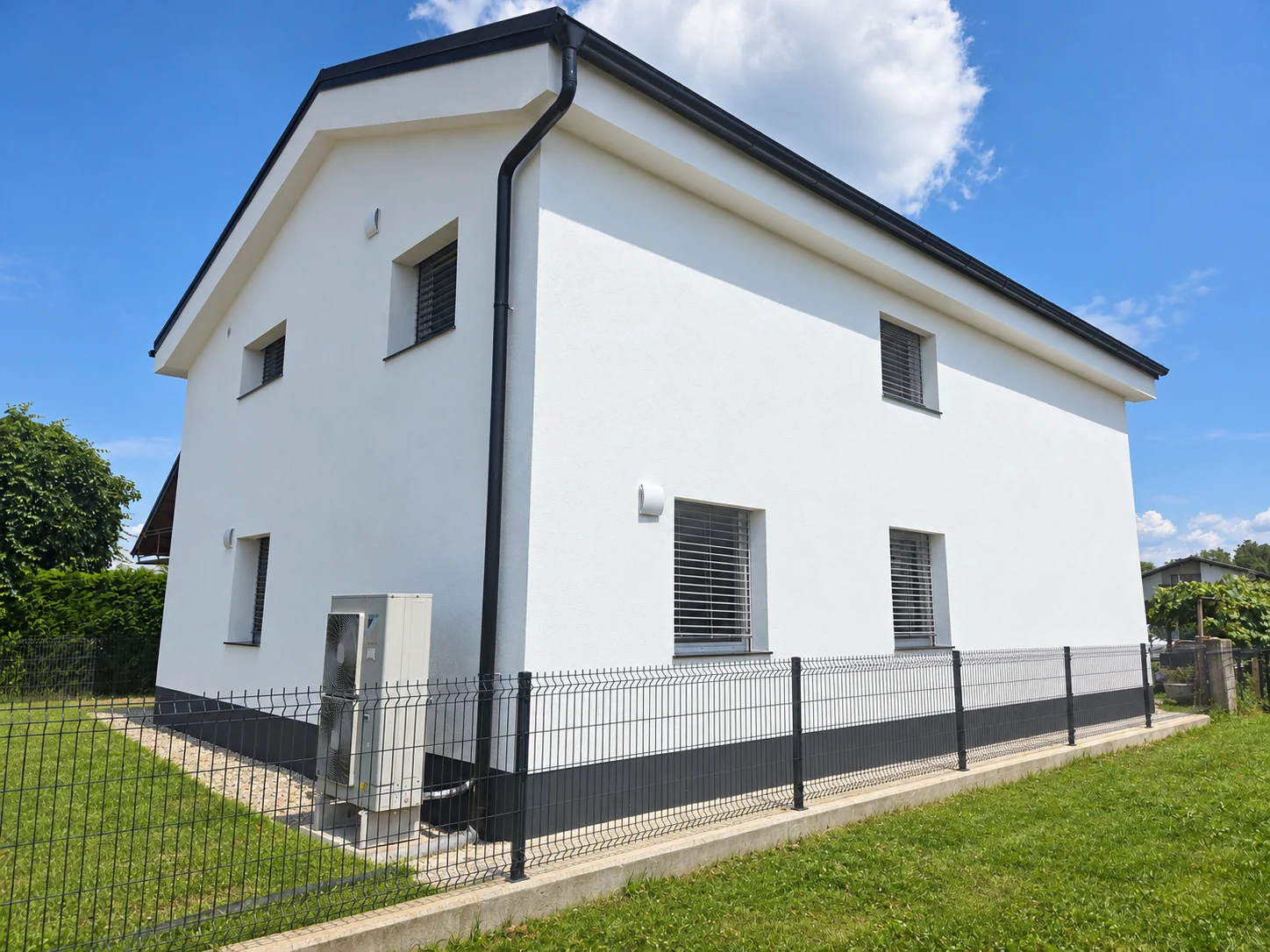 Einfamilienhaus, Blick auf Seitenfassade und Zaun